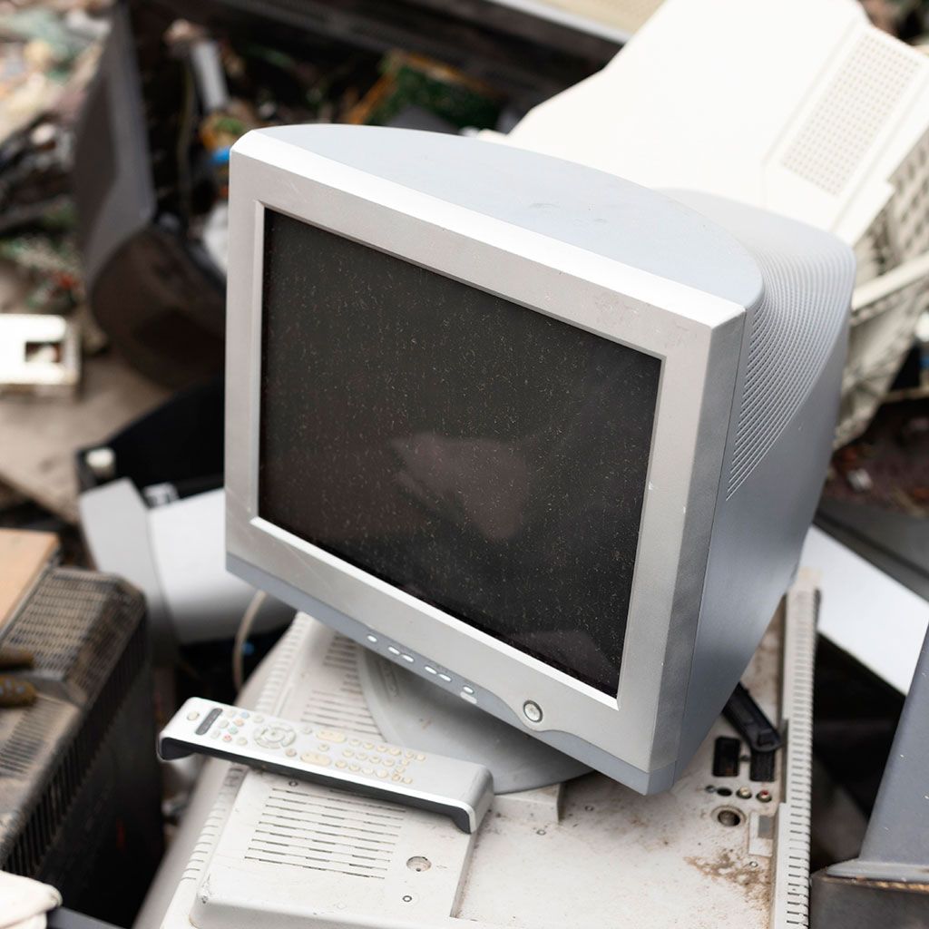 CRT monitor on top of a pile of discarded electronic waste